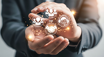 HR bubble surrounded by other bubbles symbolizing employees all being held carefully in a person's hands symbolizing the owner of the company