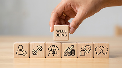 wooden blocks with the words well being on the block on top of the others