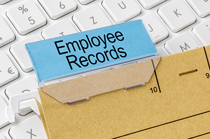 photo of a HR folder named employee records on top of a keyboard