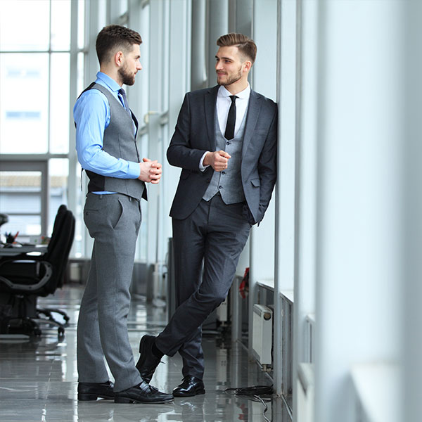 Photo of two men in business suits having a conversation. 