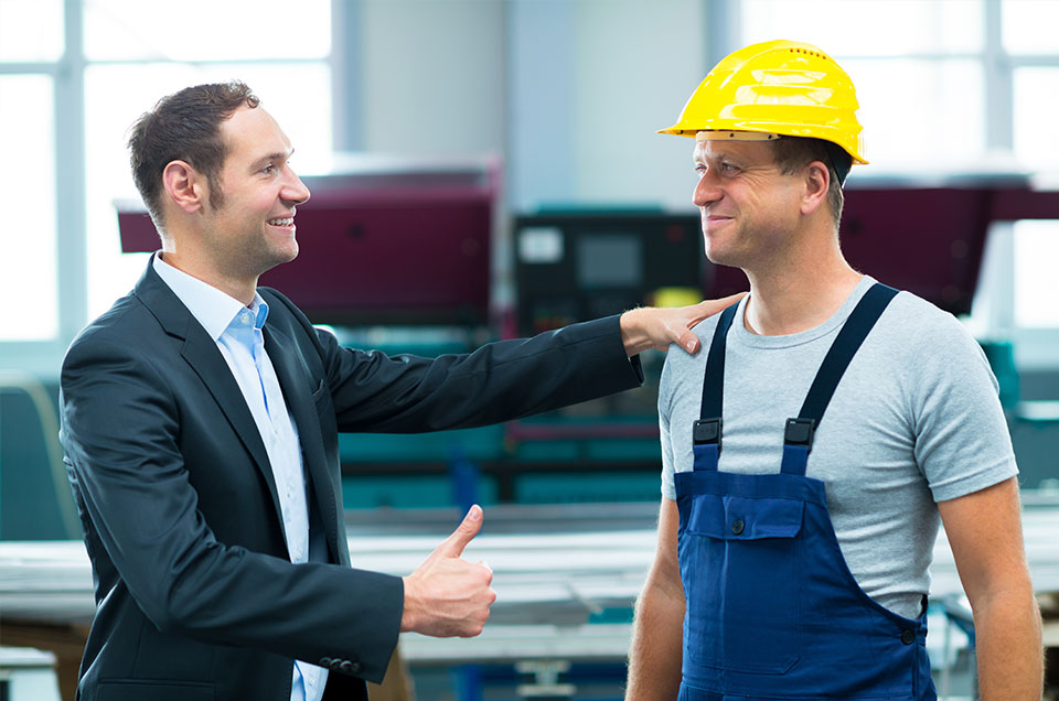 photo of business manager giving blue collar worker a thumb's up for a good job
